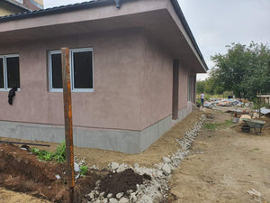 Applying Adhesive and Spackle to a House with a Metal Structure on the Ground Floor thumbnail