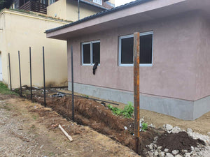 Applying Adhesive and Spackle to a House with a Metal Structure on the Ground Floor thumbnail