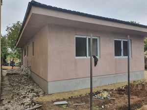 Applying Adhesive and Spackle to a House with a Metal Structure on the Ground Floor thumbnail