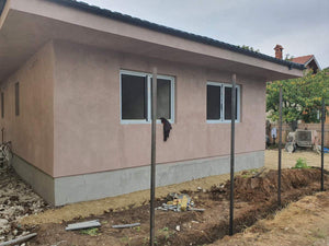 Applying Adhesive and Spackle to a House with a Metal Structure on the Ground Floor thumbnail