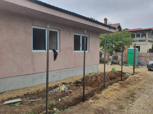Applying Adhesive and Spackle to a House with a Metal Structure on the Ground Floor thumbnail