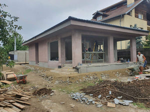 Applying Adhesive and Spackle to a House with a Metal Structure on the Ground Floor thumbnail