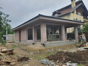 Applying Adhesive and Spackle to a House with a Metal Structure on the Ground Floor thumbnail