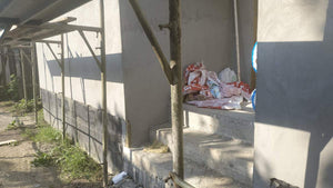 Applying Adhesive and Spackle to a House with a Metal Structure on the Ground Floor thumbnail