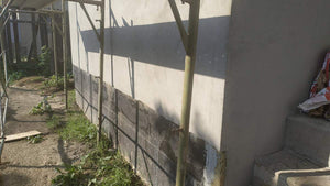 Applying Adhesive and Spackle to a House with a Metal Structure on the Ground Floor thumbnail