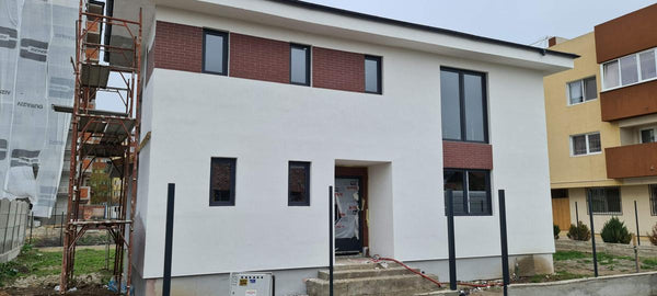 Aplicare tencuiala decorativa alba structurata pe fatada principala a casei in santier