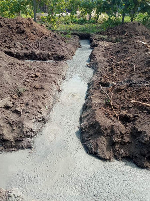 Construction of a House on a Metal Structure Pouring Concrete Mortar into Foundation Trenches thumbnail