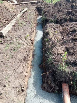 Construction of a House on a Metal Structure Pouring Concrete Mortar into Foundation Trenches thumbnail