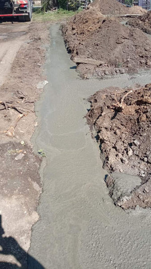 Construction of a House on a Metal Structure Pouring Concrete Mortar into Foundation Trenches thumbnail