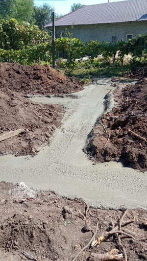 Construction of a House on a Metal Structure Pouring Concrete Mortar into Foundation Trenches thumbnail