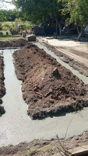 Construction of a House on a Metal Structure Pouring Concrete Mortar into Foundation Trenches thumbnail