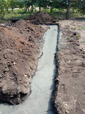Construction of a House on a Metal Structure Pouring Concrete Mortar into Foundation Trenches thumbnail