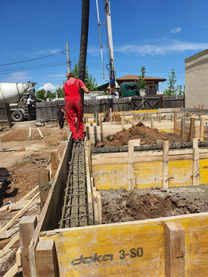 Construction of a Single-Story House Pouring Concrete into the Foundation Beams thumbnail
