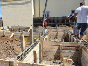 Construction of a Single-Story House Pouring Concrete into the Foundation Beams thumbnail